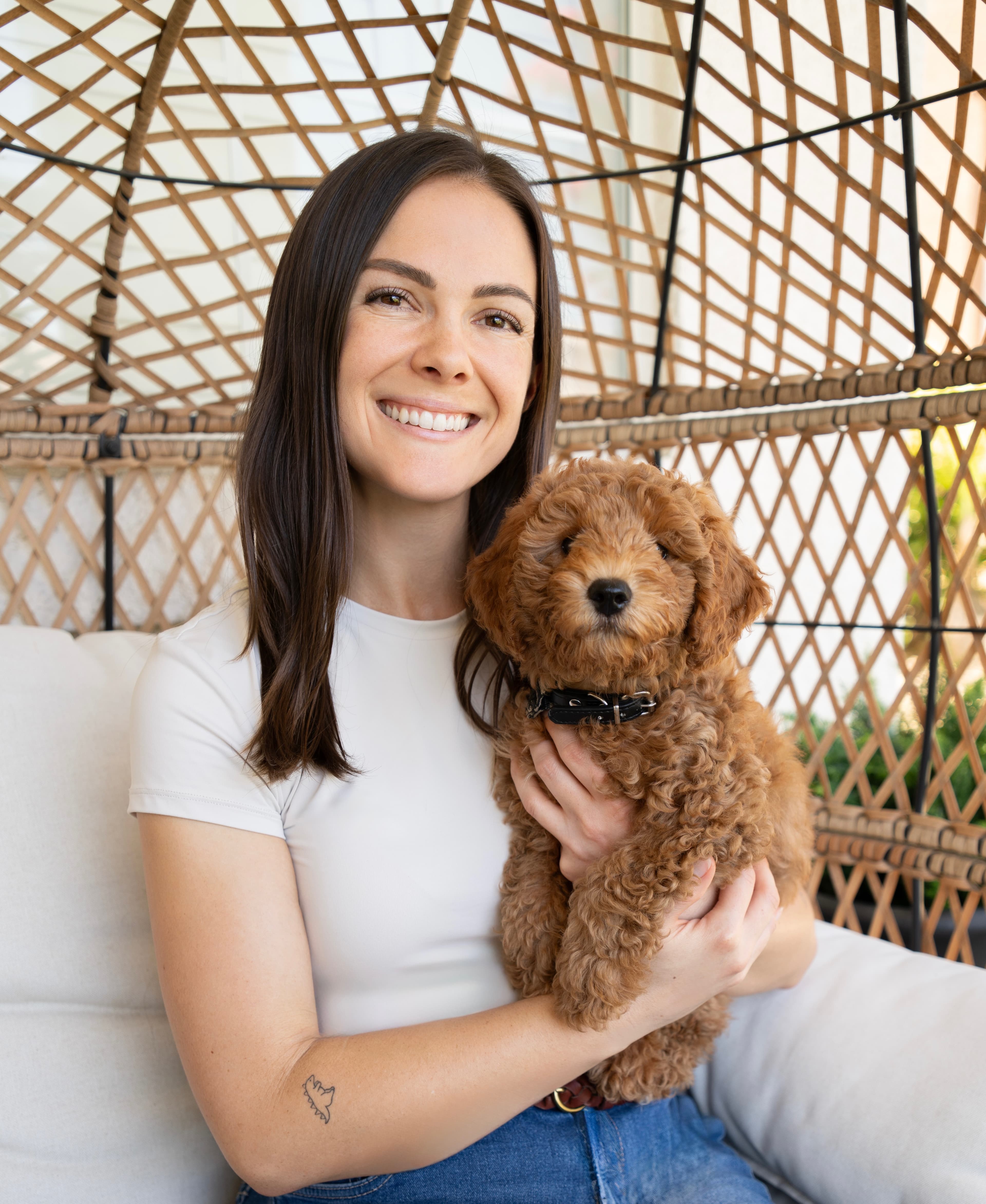 Kendall smiling while holding a brown puppy